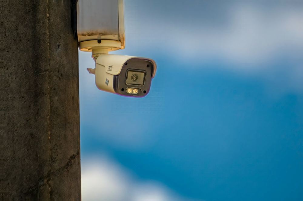 Security camera mounted on a pole against blue sky